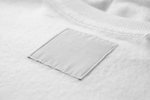 étiquette de vêtements de soin de lessive blanche vierge sur fond de texture de tissu photo