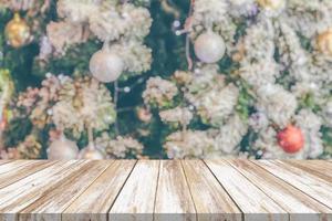 dessus de table en bois vide avec arbre de noël flou avec fond clair bokeh photo