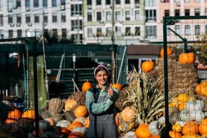 une agricultrice vend une récolte de citrouilles d'automne au marché