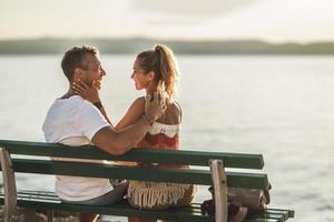 couple assis sur un banc et profitant du temps en vacances près de la plage photo