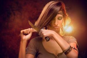 femme coupant les cheveux avec un couteau de combat photo