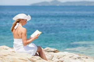 jeune femme lisant un livre sur la plage photo