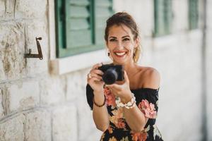 femme prenant des photos avec un appareil photo numérique tout en profitant de vacances d'été