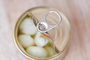 ouvrir la nourriture en conserve dans une boîte en métal sur fond de bois fermer les produits en conserve produits de stockage des aliments non périssables dans la maison de cuisine , fruits en conserve de longane photo