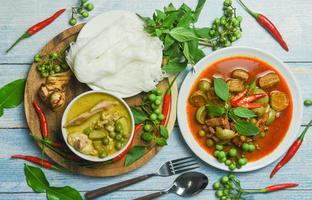 ensemble de cuisine thaïlandaise curry vert sur bol de soupe et curry rouge sur assiette avec nouilles de riz thaï vermicelle ingrédient herbe légume sur fond en bois cuisine de poulet au curry vert cuisine asiatique sur la table photo