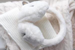 casque d'hiver blanc. écouteurs souples sur un pull blanc. photographie d'hiver confortable photo