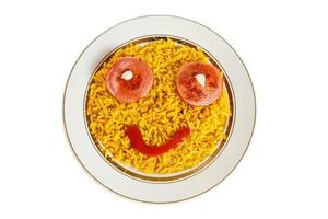 Riz jaune sur une assiette avec des saucisses en forme d'yeux, nourriture amusante isolée sur fond blanc photo