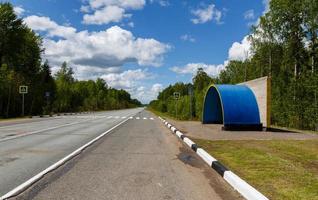 petit bâtiment d'arrêt de bus vide se dresse sur le bord de la route photo