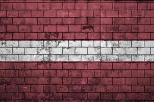 le drapeau de la lettonie est peint sur un vieux mur de briques photo