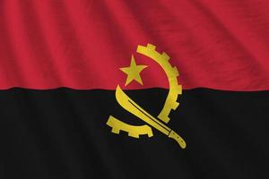 drapeau angola avec de grands plis agitant de près sous la lumière du studio à l'intérieur. les symboles et couleurs officiels de la bannière photo