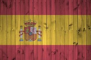 drapeau espagnol représenté dans des couleurs de peinture vives sur un vieux mur en bois. bannière texturée sur fond rugueux photo