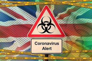 drapeau de la grande-bretagne et symbole de danger biologique covid-19 avec ruban orange de quarantaine. coronavirus ou concept de virus 2019-ncov photo