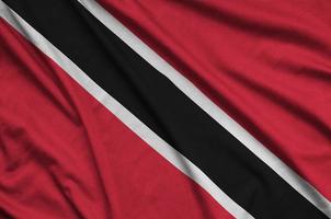 le drapeau de trinité-et-tobago est représenté sur un tissu de sport avec de nombreux plis. bannière de l'équipe sportive photo