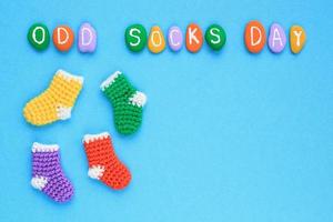 lettrage de jour de chaussettes impaires et chaussettes colorées dépareillées sur fond bleu. concept d'intimidation à l'école sociale. chaussette solitaire perdue. diversité et inclusion. vue de dessus flatlay idée d'affiche, bannière, publicité photo