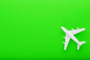 avion modèle passager blanc sur fond vert clair. espace libre pour le texte. photo
