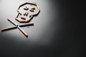 crâne de cigarettes sur fond noir. le concept de fumer tue. vers le concept du tabagisme comme une habitude mortelle, les poisons à la nicotine, le cancer du tabagisme, la maladie, l'arrêt du tabac. photo