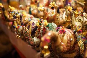 Souvenirs d'éléphants multicolores de différentes couleurs avec leur trompe relevée, jouets d'éléphants sur le marché indien. photo