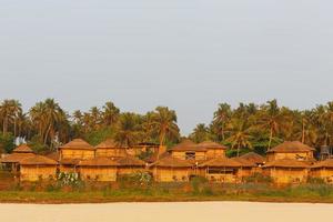 bungalow sur la côte de la mer, un réseau de maisons en roseau de bambou et feuilles de palmier. plage confortable, goa, inde. photo