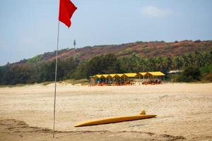 le tableau jaune du sauveteur pour le surf se trouve sur le sable utilisé par le sauveteur travaillant sur la plage d'arambol photo