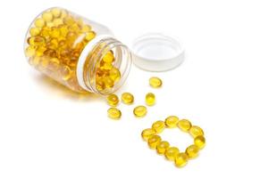 Vitamine D. bouteille de médicament et pilules jaunes renversées sur fond blanc. médicaments et pilules sur ordonnance fond plat. photo