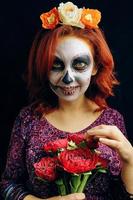 une jeune femme au jour de l'art du visage de crâne de masque mort. photo
