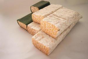 tempeh ou tempe est un aliment traditionnel indonésien à base de soja fermenté. ils sont généralement enveloppés dans des feuilles de bananier photo