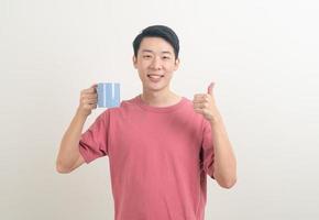 jeune homme asiatique tenant une tasse de café photo