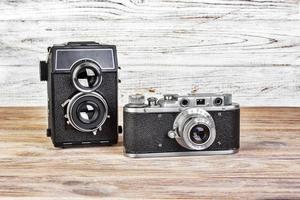 deux appareils photo vintage sur un fond en bois