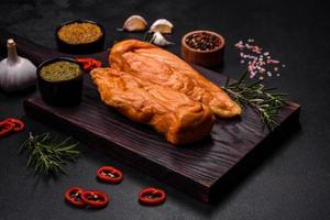 savoureux filet de poitrine de poulet fumé aux épices et herbes sur une planche à découper en bois photo