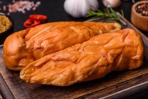 savoureux filet de poitrine de poulet fumé aux épices et herbes sur une planche à découper en bois photo