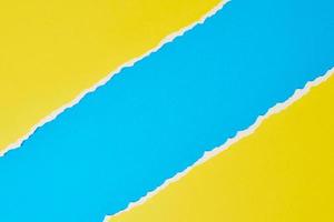 bord de papier déchiré déchiré avec un espace de copie, fond bleu et jaune de couleur photo