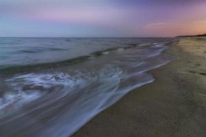 sur la plage après le coucher du soleil. belle nature aquatique à faible exposition. photo