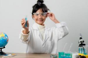 concept d'éducation, de science, de chimie et d'enfants - enfants ou étudiants avec expérience de fabrication de tubes à essai au laboratoire de l'école photo