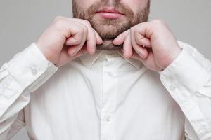 gros plan d'un homme caucasien tenant un double menton avec ses mains. l'obésité et le surpoids. concept de nutrition et de mode de vie appropriés. photo