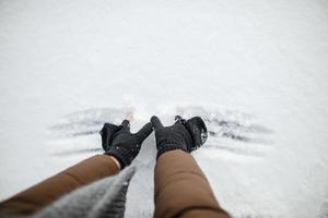 les mains masculines en mitaines font une boule de neige à partir de la neige, un jour de printemps. espace de copie. photo