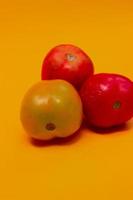 trois tomates isolées sur jaune photo