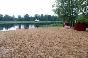 un parapluie et une clôture solitaires et affaissés, un parc pour baigner les enfants sur une plage de sable au bord d'un lac, une rivière dans un centre de loisirs, un sanatorium à l'automne par temps nuageux photo