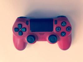 belle nouvelle manette de jeu moderne numérique rouge pour manette de jeux vidéo sur ordinateur sur fond rose photo