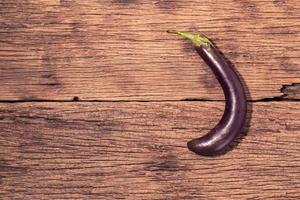 aubergine crue sur fond de bois. photo