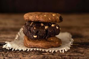 les biscuits aux arachides et au chocolat s'empilent sur une table en bois. photo