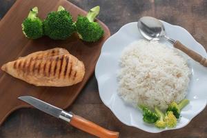 aliments sains poitrine de poulet grillades de riz a du brocoli végétal sur fond de bois. photo