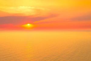 paysages marins de beau coucher de soleil sur la plage de la mer avec un ciel orange en vacances photo