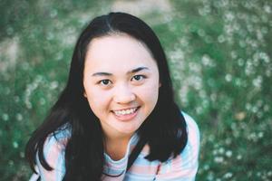 Asian girl teen sourire sur champ de fleurs effet de bruit de grain de film rétro vintage photo