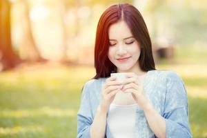 girl, adolescent, tenue, tasse, à, boire, chaud, thé, dans parc, matin, sourire photo