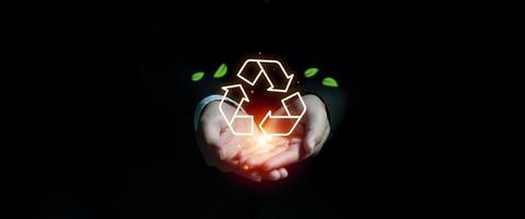 main d'homme d'affaires montrant l'icône de recyclage avec bannière de feuilles, durabilité environnementale et réduction de la pollution pour l'avenir, stratégie durable pour éliminer les déchets et la pollution pour le futur concept photo