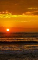 coucher de soleil doré coloré grande vague et plage puerto escondido mexique. photo