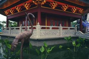 une pagode au centre d'un quartier chinois avec une statue de cigogne brune. photo