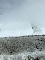 beaux paysages de station d'hiver froide de montagne avec des sommets de haute montagne brume et des rochers couverts de neige pour le snowboard et le ski contre un ciel bleu photo