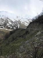 beaux paysages de station d'hiver froide de montagne avec des sommets de haute montagne brume et des rochers couverts de neige pour le snowboard et le ski contre un ciel bleu photo