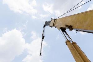 flèche de grue jaune avec crochets et fond de ciel bleu photo